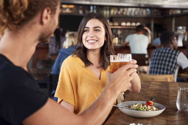 Couple On Date Meeting For Drinks And Food Making A Toast In Restaurant