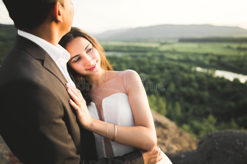 Couple de mariés sur la nature se serrent dans ses bras. belle mannequin fille en robe blanche. homme en costume images stock