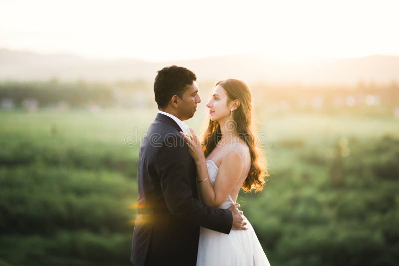 Couple de mariés sur la nature se serrent dans ses bras. belle mannequin fille en robe blanche. homme en costume photo libre de droits