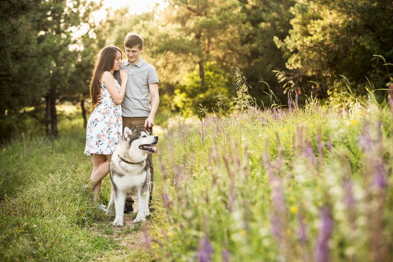 Couple with a dog stock photo. Image of malamute, husky 93821136