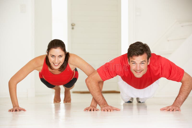 Couple doing push-ups in home gym royalty free stock photo Couple doing push-ups in home gym royalty free stock photo