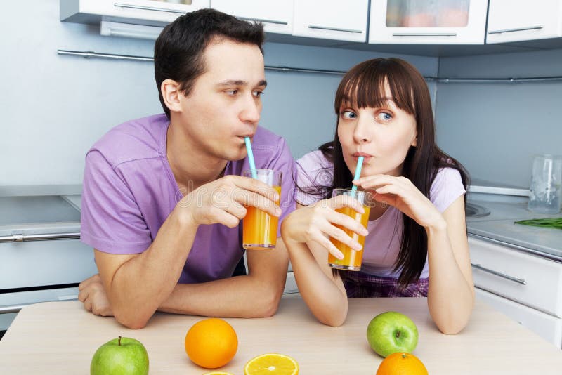 Couple drinking orange juice in the kitchen