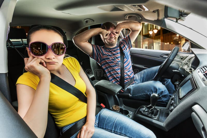 couple-driving-car-men-covering-his-eyes-hands-women-scared-75407028.jpg