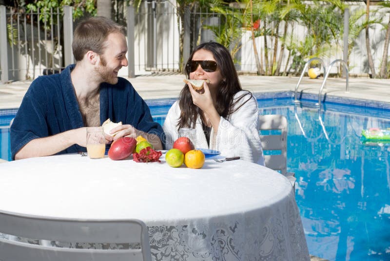 Couple Eating Fruits Near Pool - horizontal