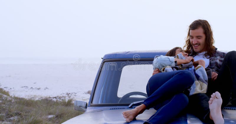 Couple embracing each other on car bonnet 4k