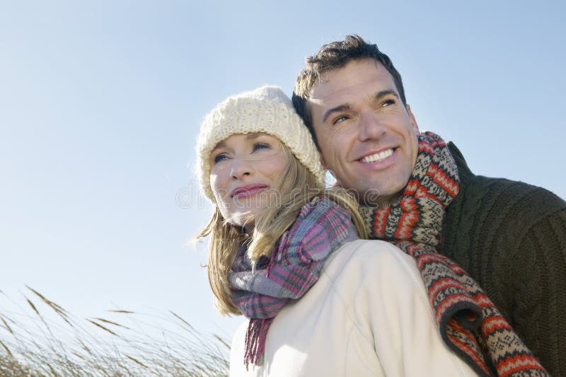 Loving couple in warm clothing embracing outdoors. Loving couple in warm clothing embracing outdoors