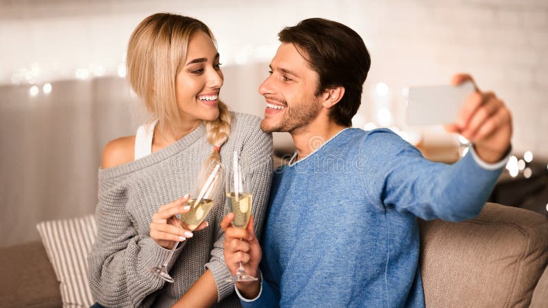 Couple en amour clinquant des lunettes de champagne et faire selfie image libre de droits