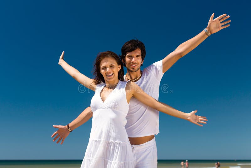Couple enjoying freedom on the beach royalty free stock image Couple enjoying freedom on the beach royalty free stock image