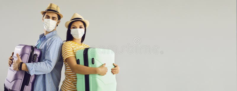 Couple in Face Masks Holding Travel Cases Standing on Light Gray Copy ...