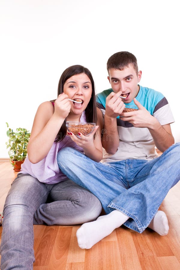 Couple on the floor eating stock image. Image of color 13381601