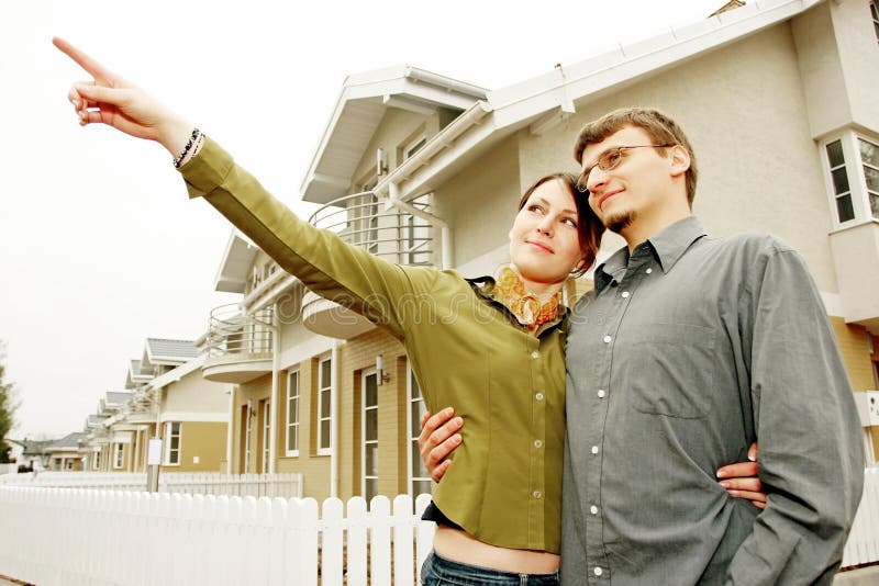 Couple in front of one-family house in modern residential area