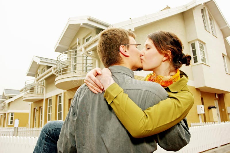 Couple in front of one-family house in modern residential area