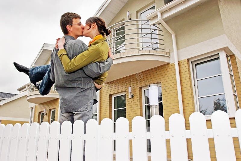 Couple in front of one-family house in modern residential area