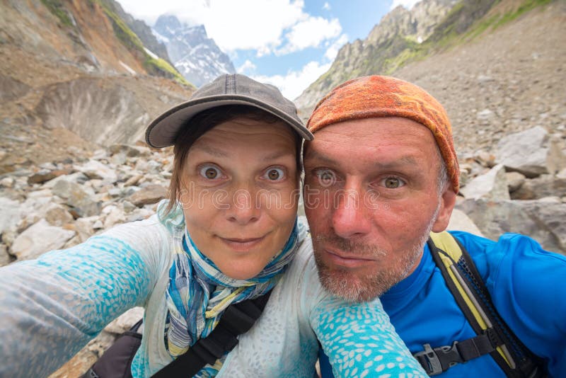 Couple of funny travelers taking selfie, during their adventure in the mountains.