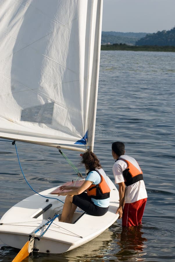 Couple Getting into Sailboat on Water - Vertical