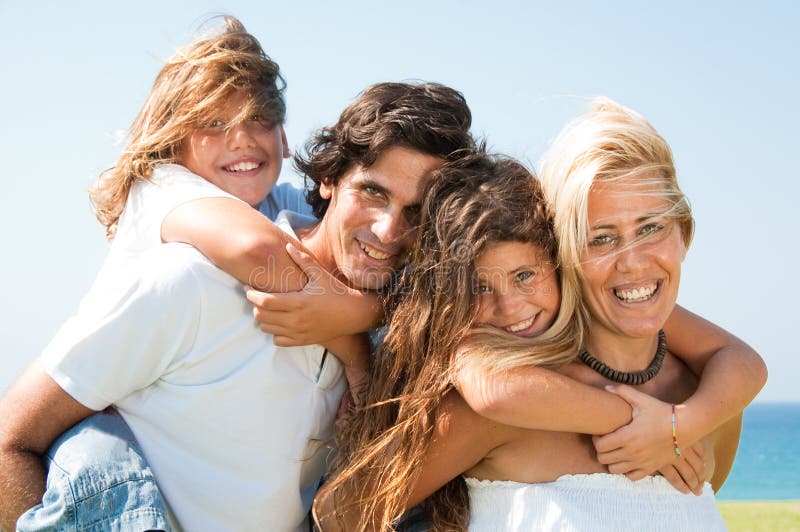 Couple giving children piggyback rides smiling