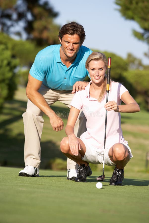 Couple Golfing On Golf Course