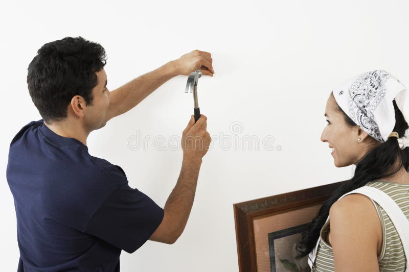 Couple Hammering Nail into Wall Stock Image - Image of latin, hammer:  29651483