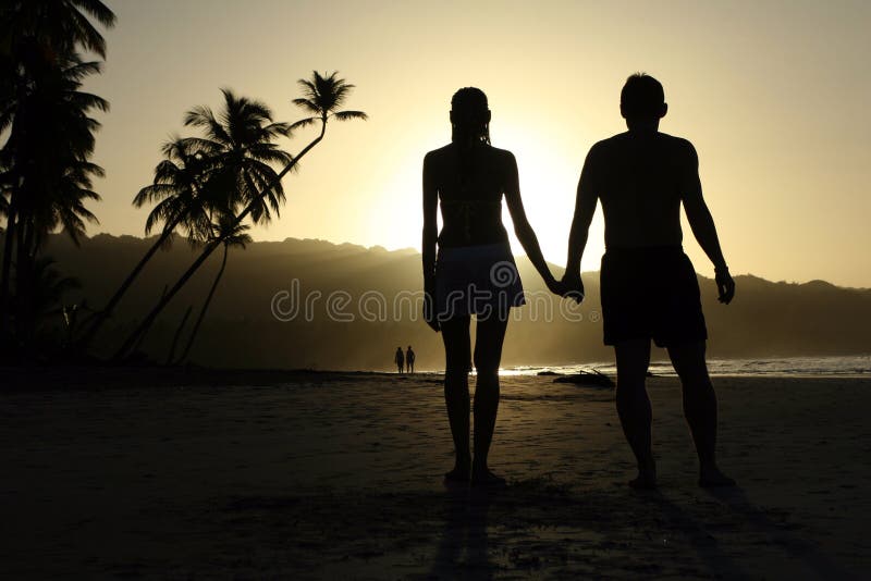 Couple hand in hand by sunset