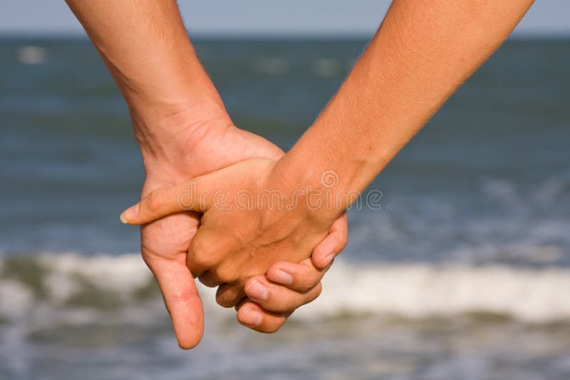 Couple of hands against the sea view. Sand fragment stock images, royalty-free photos and pictures