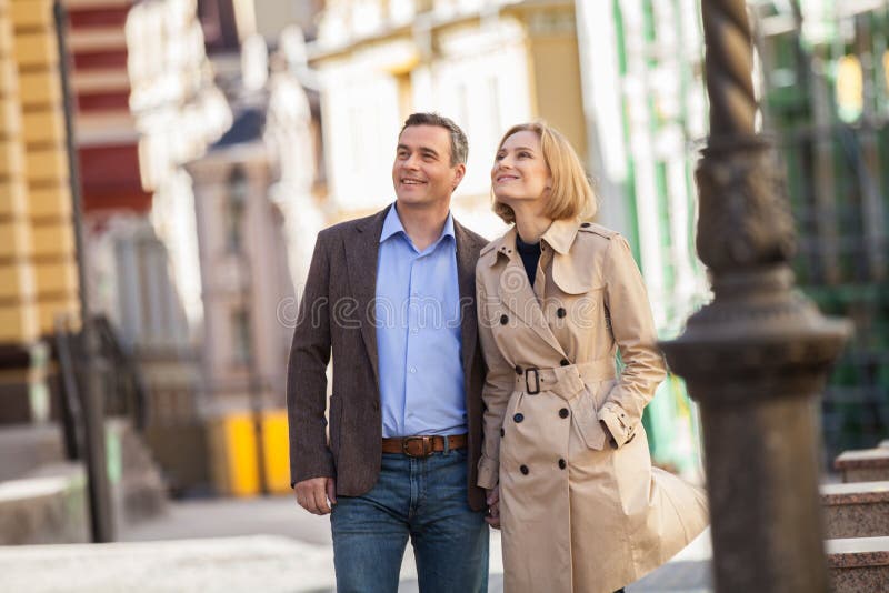 Couple having city break in summer walking on street.