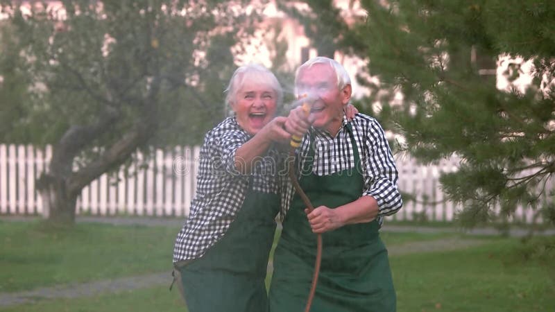 Couple having fun, water hose.