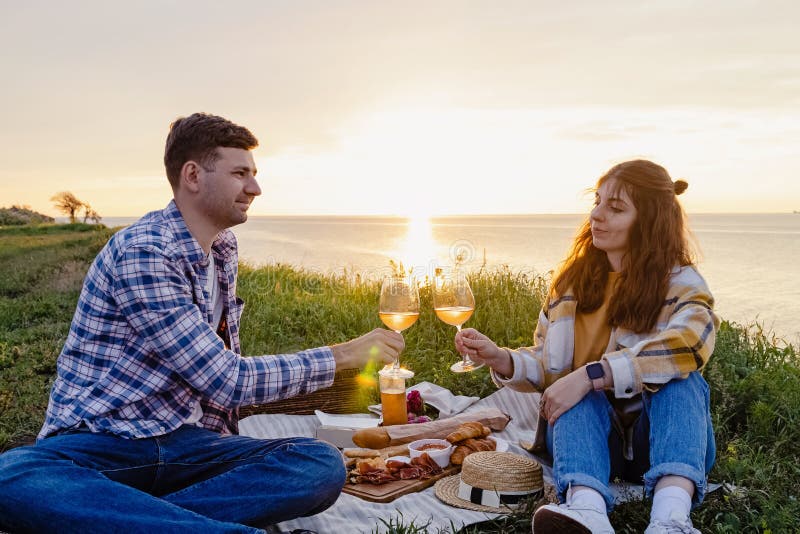 Couple having picnic on green lawn with a sea view