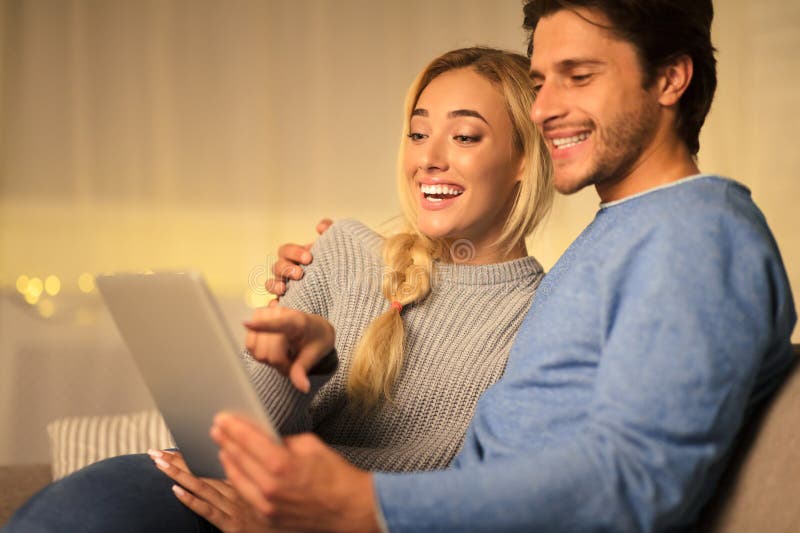 Couple heureux à la recherche de cadeaux de noël sur tablette photo libre de droits