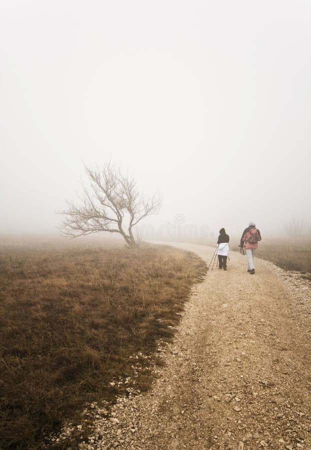 Couple hiking uphill on a bad weather day