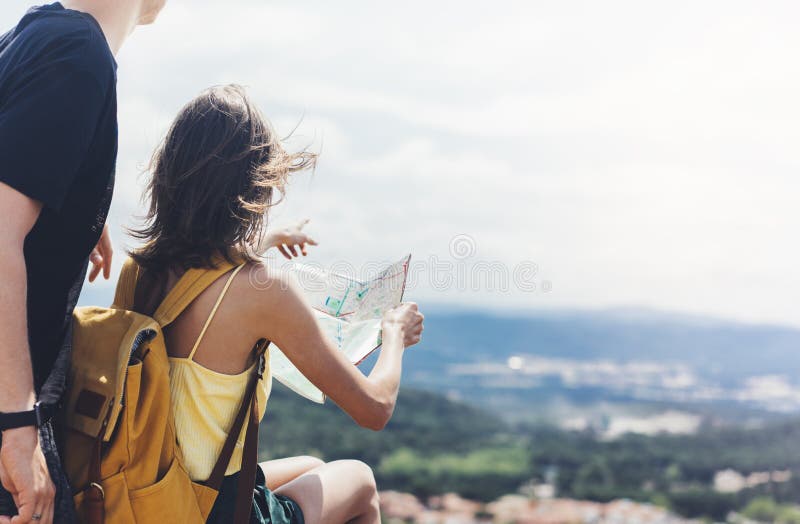 Couple hipster tourist hold and look map on trip, lifestyle concept adventure together, traveler with backpack on background mountain sea landscape horizon, young girl hiker pointing hands on trekking plan