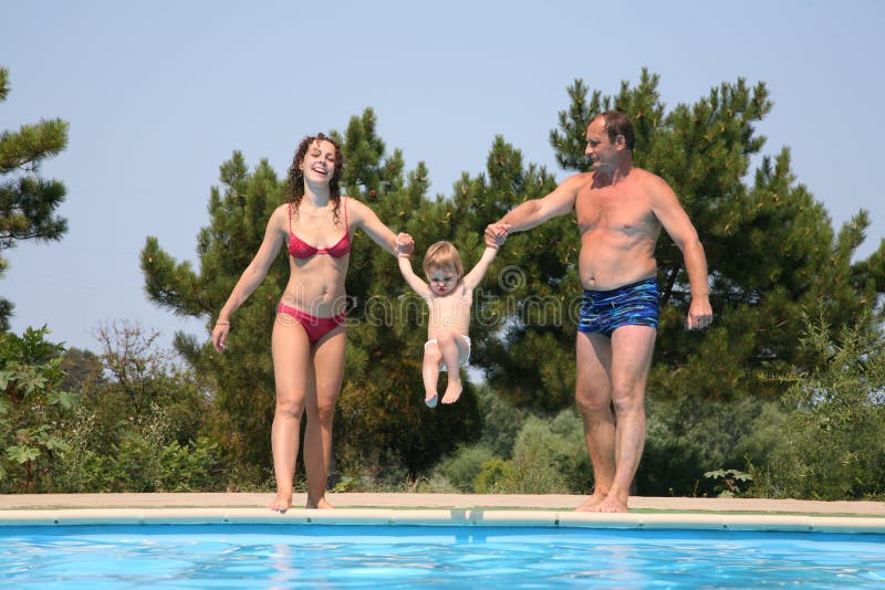 Donna e uomo in possesso di bambino e piscina.