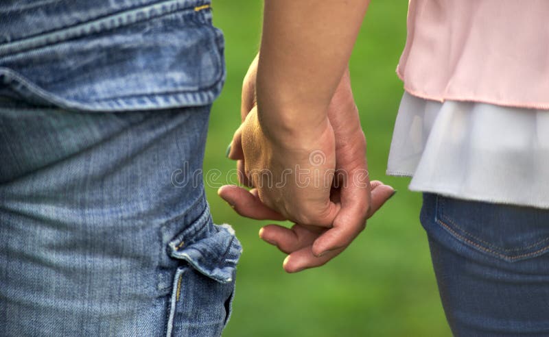 A couple holding hands. Close-up of hands