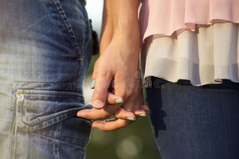 A couple holding hands. Close-up of hands