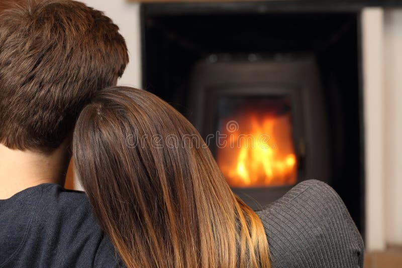 Comfortable couple hugging at home resting near fire place. Comfortable couple hugging at home resting near fire place