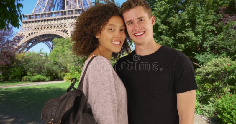 Couple joyeux près de la tour eiffel souriant et agitant à la caméra banque de vidéos