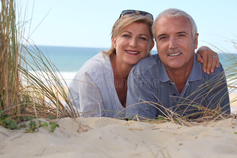 Couple laying on beach stock image