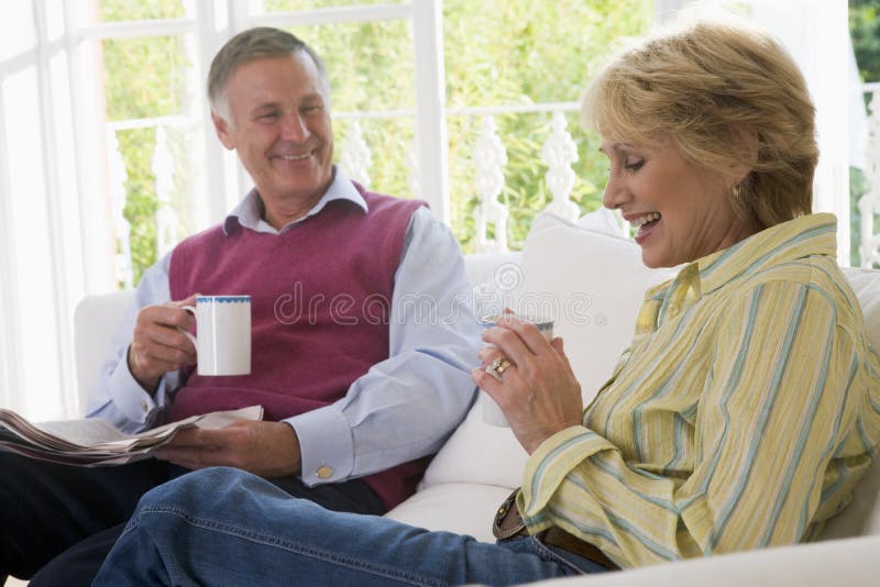 Couple in living room with coffee and newspaper