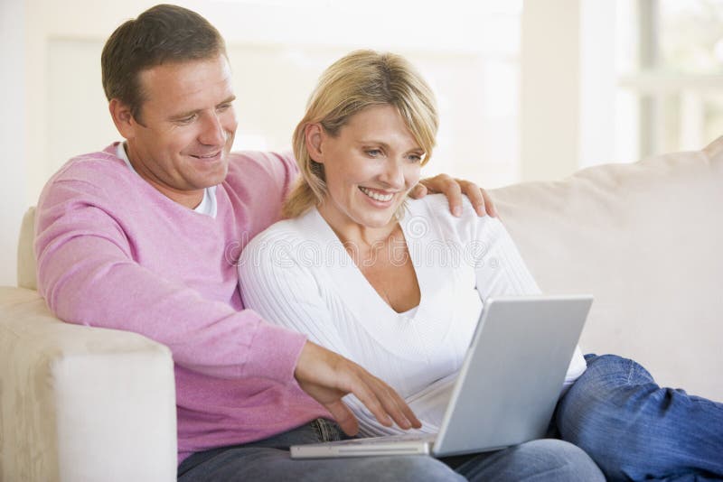 Couple in living room using laptop and