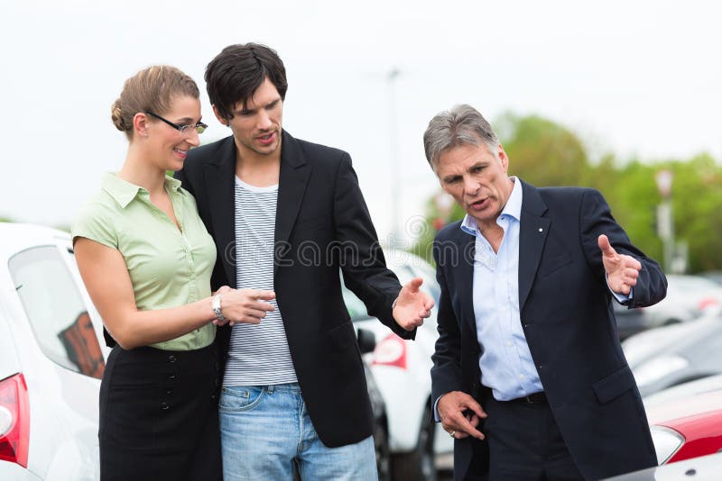 Couple looking at car on yard of dealer