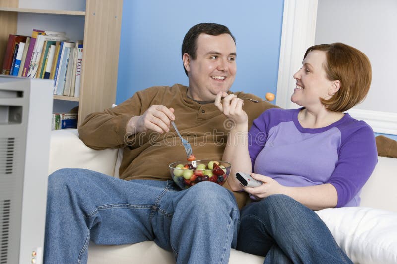 Couple Looking At Each Other While Eating Fruits