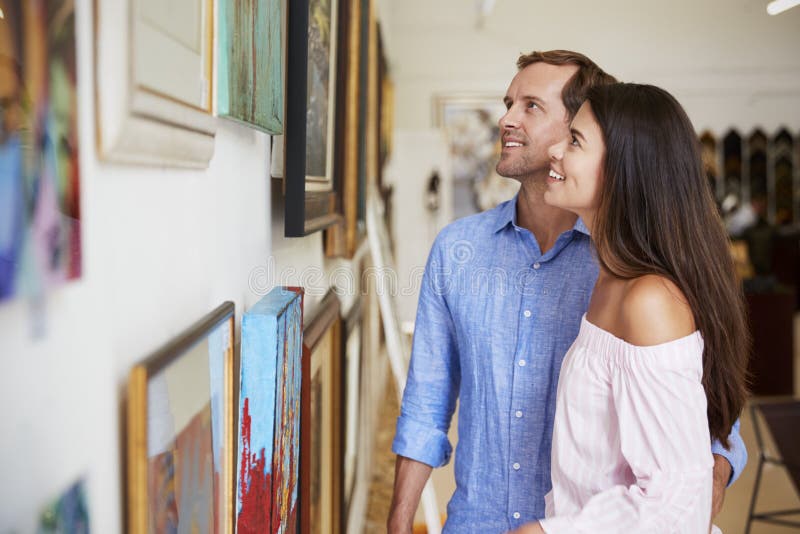 Couple Looking At Paintings In Art Gallery Together
