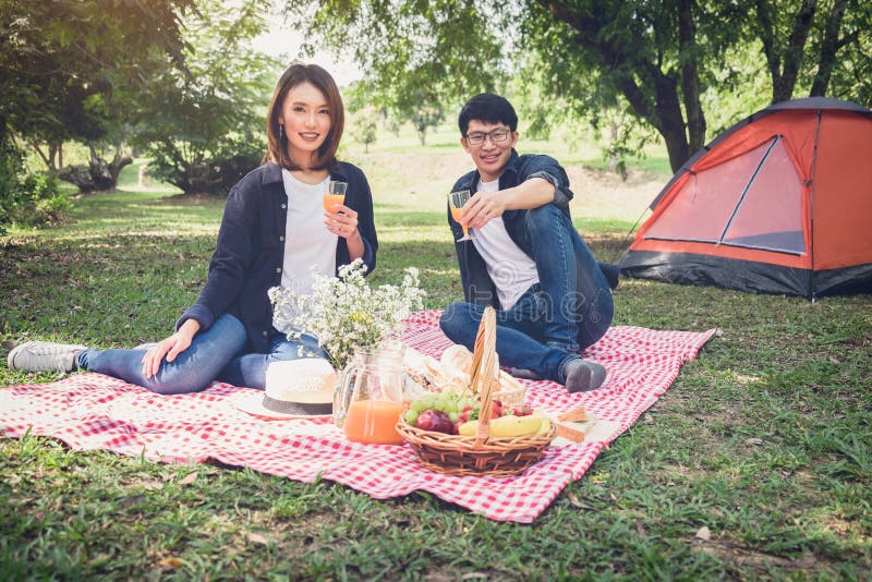 Couple in love drink a orange juice on summer picnic, leisure, h