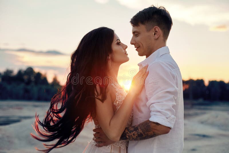 Couple in love hugs kiss happy life, man and woman, the sunset, the sun rays, a couple in love looking each other in the eye. stock photography Couple in love hugs kiss happy life, man and woman, the sunset, the sun rays, a couple in love looking each other in the eye. stock photography