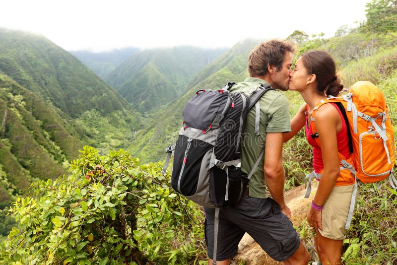 Couple in love kissing while hiking on Hawaii. Romantic young couple hikers during hike in beautiful mountain forest nature. Healthy lifestyle multi-ethnic couple on Waihee ridge trail, Maui, USA