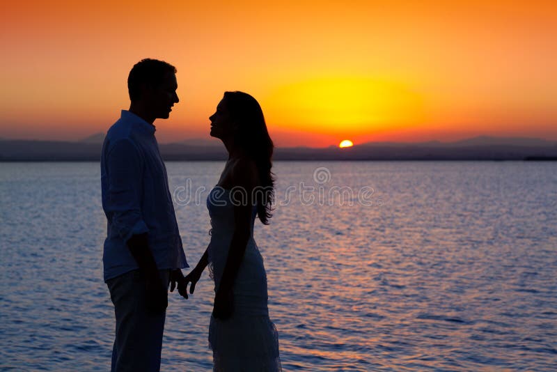 Couple in love silhouette at lake sunset stock image