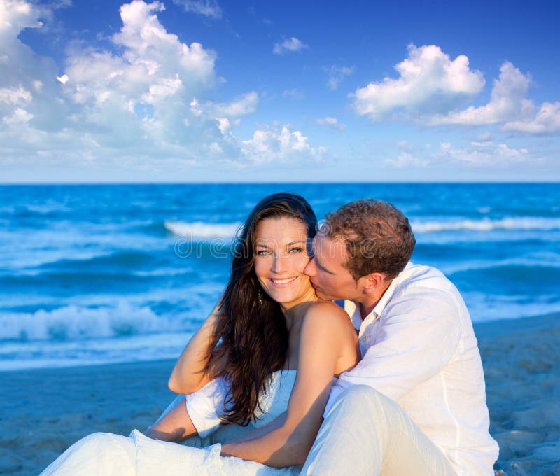 Couple in love sitting in blue beach