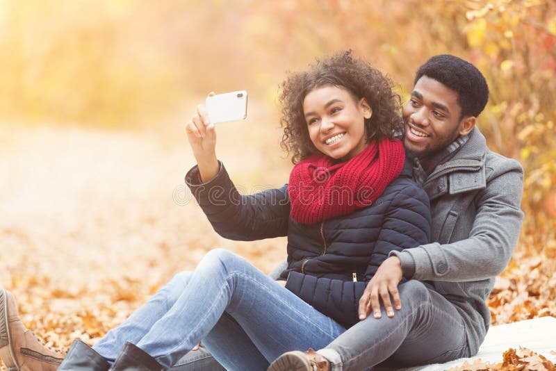 Couple in love taking selfie, having picnic in park stock image Couple in love taking selfie, having picnic in park stock image