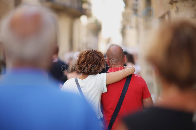 Couple of lovers on the street of an Italian ancient city in a crowd of tourists