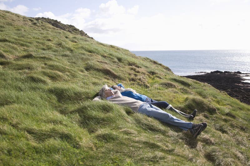 Couple Lying On Coastal Landscape royalty free stock images