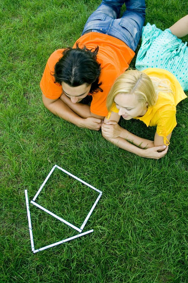 Couple lying on grass with model house stock photos Couple lying on grass with model house stock photos